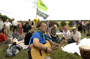 photo du picnic, un homme jouant de la guitare et le drapeau d'EELV au fond